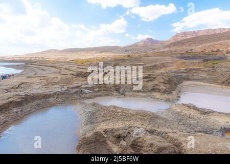 Buca piena di acque turchesi, vicino alla costa del Mar Morto. Foro formato quando il sale sotterraneo è dissolto da intrusione di acqua dolce, dovuto la caduta continua del livello del mare. . Foto di alta qualità Foto Stock