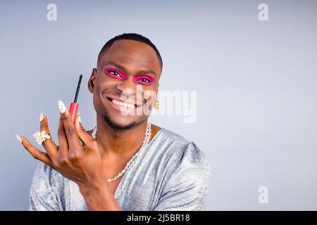 visagista afroamericano con anello perla sul dito e collana perline bijouterie sul collo indossando eleganti donne lucenti vestire con magnifico Foto Stock