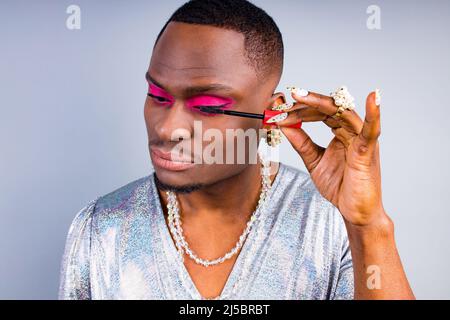 visagista afroamericano con anello perla sul dito e collana perline bijouterie sul collo indossando eleganti donne lucenti vestire con magnifico Foto Stock