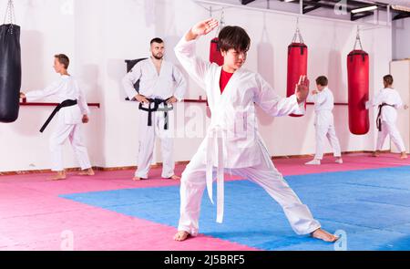 Ragazzi allenano i movimenti del karate in palestra Foto Stock