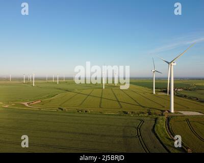 Drone aereo. Wind farm nei campi nel sud-est dell'Inghilterra. Turbine eoliche vicino a Camber Sands e Rye, East Sussex. Foto Stock