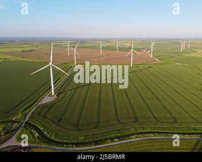 Drone aereo. Wind farm nei campi nel sud-est dell'Inghilterra. Turbine eoliche vicino a Camber Sands e Rye, East Sussex. Foto Stock