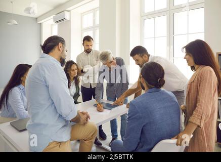 Gruppo di persone che hanno una discussione durante un incontro con un esperto business coach Foto Stock