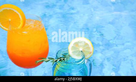 Vista ravvicinata di due bicchieri di cocktail esotici di frutta ghiacciata non alcolica vicino alla piscina Foto Stock