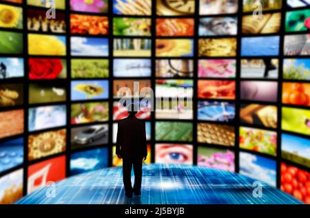 uomo all'interno di una stanza con molti schermi con immagini Foto Stock
