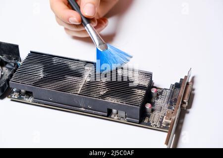 La procedura guidata del computer rimuove la polvere dalla scheda video. Foto Stock