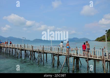 Edificio classico ponte passerella in legno per la gente tailandese e viaggiatori stranieri a piedi andare a traghetto nave barca al molo del porto e in mare oceano a Koh Foto Stock