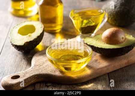 Olio e avocado fresco maturo su tavola rustica in legno Foto Stock