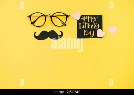 Concetto di giorno dei padri felici. Vista dall'alto degli occhiali, carta con frase Happy father's day e retro elegante cabina fotografica nera di carta props moustaches su y Foto Stock