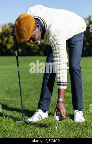 uomo afroamericano bearded che mette la sfera sul tee di golf Foto Stock