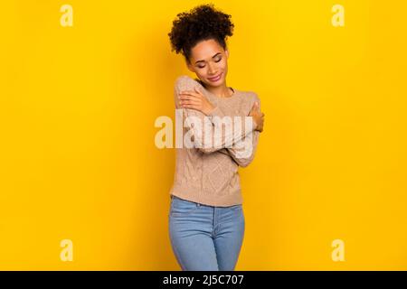 Foto di dolce donna lucida vestito pullover beige occhi chiusi abbracciandosi isolato colore sfondo giallo Foto Stock