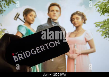 Rheinbach, Germania 21 aprile 2022, il logo della nuova serie Netflix 'Bridgerton' sul display di uno smartphone davanti alla TV Foto Stock