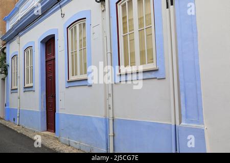 Mauve incorniciata parete bianca-una storia Townhouse-porta in legno maroon. Lagos-Portogallo-224 Foto Stock