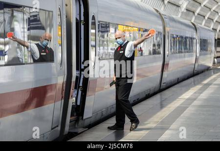 'Berlin, DEU, 27.05.2020 - Un assistente di treno che indossa una maschera facciale dà al conducente del motore il segnale di partenza alla stazione di Berlino Spandau. Il ministro federale dei trasporti, Deutsche Bahn e il comitato aziendale concludono una ''Alleanza per le nostre ferrovie''. L'alleanza vuole regolare le conseguenze finanziarie della pandemia di Corona per le ferrovie i miliardi previsti in aiuti a Deutsche Bahn nella crisi di Corona si incontrano con le preoccupazioni dell'Unione GDL. [traduzione automatizzata]' Foto Stock