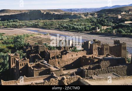 10.11.2010, Ouarzazate, Marocco, Africa - Vista dall'alto dell'architettura degli antichi edifici in adobe della storica fortezza di Ait-ben-Haddouh, un sito patrimonio dell'umanità dell'UNESCO lungo l'ex strada carovana tra il Sahara e Marrakech. Il sito ha fatto da sfondo a numerose produzioni cinematografiche, da Lawrence of Arabia a James Bond e Game of Thrones. Sullo sfondo si può vedere la stretta valle del fiume Asif Mellah. [traduzione automatizzata] Foto Stock