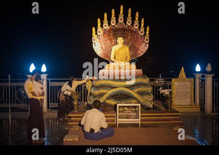 30 gennaio 2017, Mawlamyine, Repubblica dell'Unione di Myanmar, Asia - credenti di fronte a una figura di Buddha illuminata alla Pagoda di Kyaikthanlan, la pagoda buddista più alta della città. [traduzione automatizzata] Foto Stock