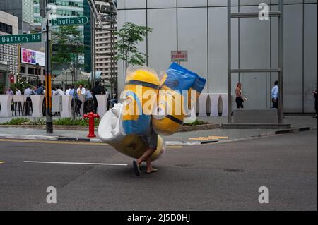 23 agosto 2018, Singapore, Repubblica di Singapore, Asia - Un uomo cammina lungo una strada al Raffles Place nel centro della città indossando costumi a metà corpo di 3D personaggi animati del cinema Minions. [traduzione automatizzata] Foto Stock