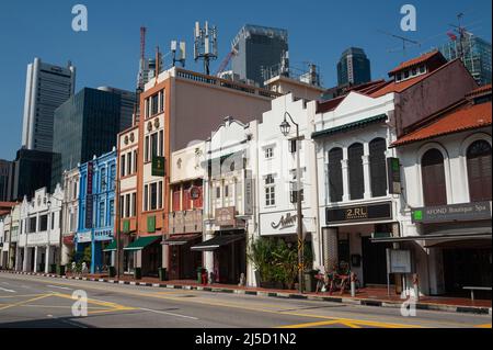 25.05.2021, Singapore, Repubblica di Singapore, Asia - Vista della via deserta di South Bridge Road con i suoi edifici tradizionali (botteghe) a Chinatown e i grattacieli del quartiere degli affari che torreggiano sullo sfondo durante la crisi della corona in corso (Covid-19), Poco dopo una nuova ondata di infezione ha riportato il paese del sud-est asiatico in uno stato simile a un blocco. Ciò ha portato a ulteriori restrizioni, come ad esempio misure più severe alle frontiere e requisiti di ingresso, unitamente a test preliminari obbligatori e a risultati negativi alla partenza per tutti i residenti locali e residenti permanenti, come Foto Stock