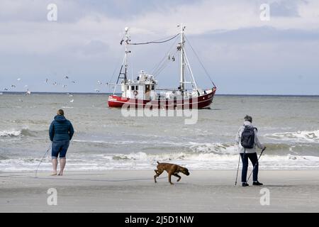 Amrum Island,Sueddorf, 27.05.2021 - i villeggianti camminano a temperature fresche sulla spiaggia di Sueddorf sull'isola di Amrum, vicino ad un peschereccio. A causa della diminuzione dei valori di incidenza, è possibile di nuovo viaggiare. Viaggiare a Schleswig Holstein solo con esito negativo del test. In loco, è necessario eseguire nuovamente un test Corona Rapid ogni 72 ore. [traduzione automatizzata] Foto Stock