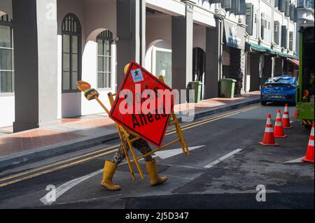 23 settembre 2021, Singapore, Repubblica di Singapore, Asia - Un operaio del centro porta un dispositivo con un cartello stradale e una spia durante la crisi di Corona in corso. [traduzione automatizzata] Foto Stock