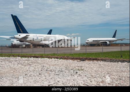 11 ottobre 2021, Singapore, Repubblica di Singapore, Asia - due linee aeree Singapore (sia) smantellate Airbus A380s e un Boeing 777-200 sono parcheggiati presso il Changi Exhibition Centre in attesa di smantellamento. L'aeromobile passeggeri verrà smantellato in un processo che richiederà circa due mesi e le parti utilizzabili verranno utilizzate come parti di ricambio per il resto della flotta. Il disassemblaggio dell'aeromobile viene effettuato dal dipartimento di ingegneria della compagnia aerea, sia Engineering, e segna la prima volta che sia ha smontato l'aeromobile sul sito. [traduzione automatizzata] Foto Stock