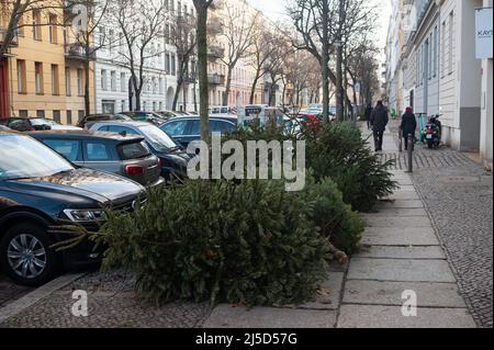 11 gennaio 2022, Berlino, Germania, Europa - alberi di Natale scartati e consumati senza decorazioni per alberi di Natale si trovano sul lato della strada in una zona residenziale nel quartiere Mitte pronto per essere prelevato dal servizio di pulizia della città di Berlino (BSR). [traduzione automatizzata] Foto Stock