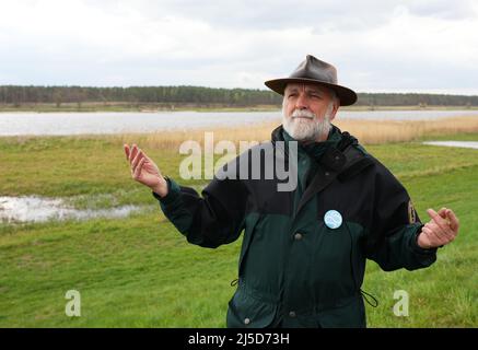 Brandeburgo, Germania. 22nd Apr 2022. 22 aprile 2022, Brandeburgo, Angermünde/OT Criewen: Michael Tautenhahn, Vice Direttore del Parco Nazionale della bassa Valle dell'Oder, parla al Parco Nazionale della bassa Valle dell'Oder, vicino alla torre panoramica di Stützkow sulle rive del fiume Oder. Il Centro Nabu Blumberger Mühle, insieme all'Istituto Leibniz di Ecologia dell'acqua dolce e della pesca interna (IGB) e alla gestione dello stagno Blumberger Teiche, ha rilasciato circa 500 giovani storioni baltici nel fiume Oder. Lo stoccaggio di storioni nel fiume di confine è in corso da quindici anni, e gli sforzi per rei Foto Stock