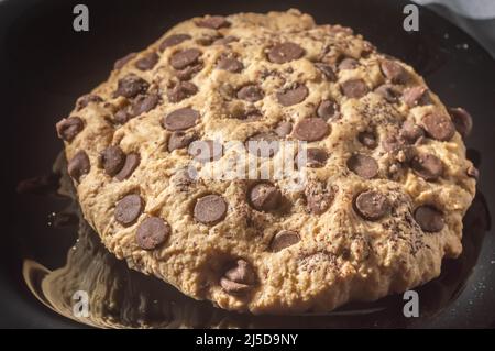 Biscotto grande con gocce di cioccolato con luce naturale, concetto di ricetta fatta in casa. Foto Stock