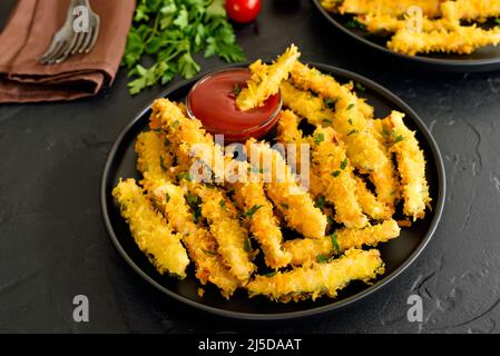 Bastoncini di zucchine fritti e salsa di pomodoro sul piatto, vista ravvicinata Foto Stock