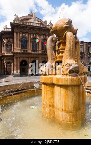 Fontana dei Delfini, Centro Catania. Piccola fontana a tema di delfini con il teatro dell'opera sullo sfondo. Piazza Teatro. Centro di Catania. Sicilia. Italia. (129) Foto Stock