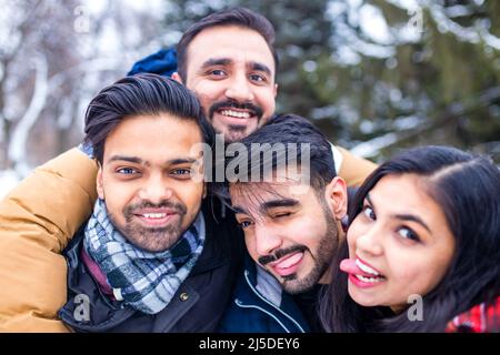 Ragazzi arabi che hanno grande tempo per le vacanze di Natale prendendo selfie foto al telefono Foto Stock