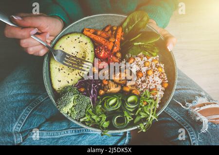 Donna che tiene piatto con cibo vegano o vegetariano. Dieta sana. Cena o pranzo a base di verdure sane. Gustosa ciotola di buddha. Cibo vegano sano Foto Stock