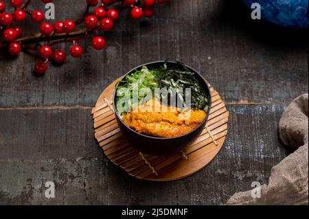 Sea Urchin Chawanmushi in un piatto con bacchette isolate su stuoia vista laterale su tavola di legno taiwan cibo Foto Stock