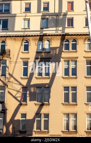 Gettare l'ombra di una ruota di ferro sulla facciata degli edifici. Luce notturna. Bruxelles Foto Stock