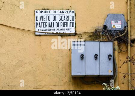 Segno di divieto di scarico dei rifiuti appesi accanto ai contatori di elettricità in una strada del centro storico, Sanremo, Imperia, Liguria, Italia Foto Stock