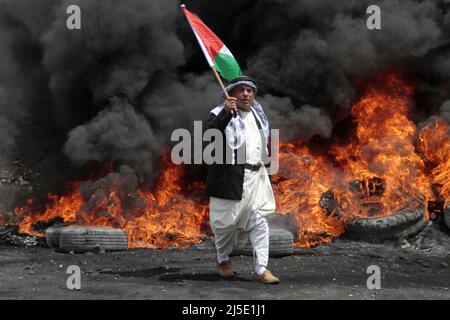 Nablus, Palestina. 22nd Apr 2022. Il manifestante palestinese ha visto sventolare una bandiera, durante la manifestazione contro gli insediamenti israeliani nel villaggio di Kafr Qaddaum, vicino alla città di Nablus, in Cisgiordania. (Foto di Nasser Ishtayeh/SOPA Images/Sipa USA) Credit: Sipa USA/Alamy Live News Foto Stock