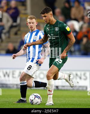 Lewis o'Brien di Huddersfield Town (a sinistra) e Matthew Wolfe di Barnsley combattono per la partita del campionato Sky Bet al John Smith's Stadium di Huddersfield. Data foto: Venerdì 22 aprile 2022. Foto Stock