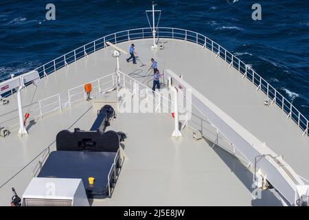 Lavoratori che puliscono l'arco della regina Cunard Maria 2 durante un viaggio transatlantico Foto Stock