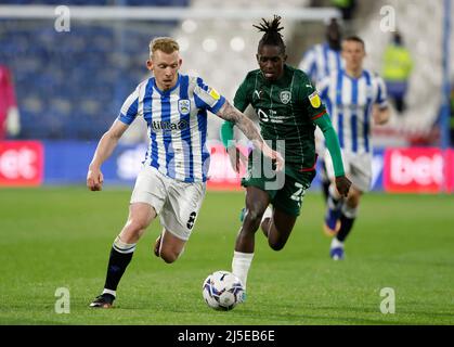 Lewis o'Brien di Huddersfield Town (a sinistra) e Domingos Quina di Barnsley in azione, Lewis o'Brien di Huddersfield Town e Dominik Frieser di Barnsley durante la partita del campionato Sky Bet al John Smith's Stadium, Huddersfield. Data foto: Venerdì 22 aprile 2022. Foto Stock