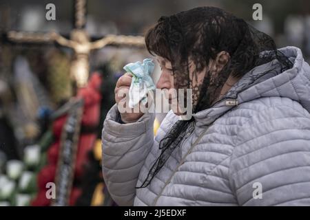 Irpin, Ucraina. 22nd Apr 2022. Kateryna Kravchenko, 61, pulisce le lacrime dopo che ha sepolto sua sorella Soroka Vira Stepanovna, 69, in un cimitero a Irpin Venerdì, 22 aprile 2022. Nonostante i danni arrecati agli appartamenti delle sorelle dagli attacchi russi, la causa della morte era l'insufficienza cardiaca. Un comandante militare a Mosca ha detto venerdì che l'obiettivo della nuova fase della guerra della Russia è quello di assumere il pieno controllo dell'Ucraina meridionale e orientale e di collegare la regione di Donbas con la Crimea via terra. Foto di Ken Cedeno/UPI . Credit: UPI/Alamy Live News Foto Stock