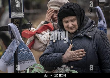 Irpin, Ucraina. 22nd Apr 2022. Svitlana Pavlivna Fedorenko, 76 rende omaggio a Fedorenko Viktor Dmytrevych, 86 in un cimitero di Irpin Venerdì 22 aprile 2022. Dmytrevych era un chirurgo e morì di polmonite causata da COVID dopo aver vissuto e nascosto in un seminterrato per un mese dai soldati russi. Un comandante militare a Mosca ha detto venerdì che l'obiettivo della nuova fase della guerra della Russia è quello di assumere il pieno controllo dell'Ucraina meridionale e orientale e di collegare la regione di Donbas con la Crimea via terra. Foto di Ken Cedeno/UPI . Credit: UPI/Alamy Live News Foto Stock