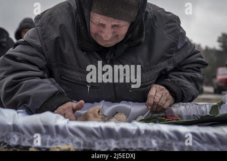 Irpin, Ucraina. 22nd Apr 2022. Un uomo paga i suoi rispetti a Fedorenko Viktor Dmytrevych, 86 in un cimitero a Irpin Venerdì, 22 aprile 2022. Dmytrevych era un chirurgo e morì di polmonite causata da COVID dopo aver vissuto e nascosto in un seminterrato per un mese dai soldati russi. Un comandante militare a Mosca ha detto venerdì che l'obiettivo della nuova fase della guerra della Russia è quello di assumere il pieno controllo dell'Ucraina meridionale e orientale e di collegare la regione di Donbas con la Crimea via terra. Foto di Ken Cedeno/UPI Credit: UPI/Alamy Live News Foto Stock