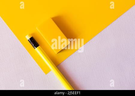 vista dall'alto di matita e gomma su giallo e bianco Foto Stock