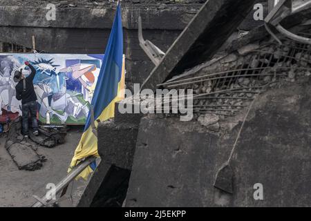 Kiev, Ucraina. 22nd Apr 2022. Roberto Marquez, pittore messicano, lavora su un nuovo dipinto presso il ponte distrutto che attraversa il fiume Irpin dalla città di Irpin, a soli 20 chilometri a nord-ovest di Kyiv, Ucraina venerdì 22 aprile 2022. Il ponte fu fatto saltare in aria dalle forze ucraine per bloccare - o almeno rallentare - l'armatura russa che raggiungeva Kiev, la capitale dell'Ucraina. Un comandante militare a Mosca ha detto venerdì che l'obiettivo della nuova fase della guerra della Russia è quello di assumere il pieno controllo dell'Ucraina meridionale e orientale e di collegare la regione di Donbas con la Crimea via terra. Foto di Ken Cedeno/UPI . Credito Foto Stock
