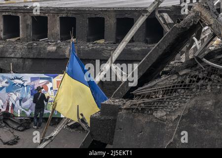 Kiev, Ucraina. 22nd Apr 2022. Roberto Marquez, pittore messicano, lavora su un nuovo dipinto presso il ponte distrutto che attraversa il fiume Irpin dalla città di Irpin, a soli 20 chilometri a nord-ovest di Kyiv, Ucraina venerdì 22 aprile 2022. Il ponte fu fatto saltare in aria dalle forze ucraine per bloccare - o almeno rallentare - l'armatura russa che raggiungeva Kiev, la capitale dell'Ucraina. Un comandante militare a Mosca ha detto venerdì che l'obiettivo della nuova fase della guerra della Russia è quello di assumere il pieno controllo dell'Ucraina meridionale e orientale e di collegare la regione di Donbas con la Crimea via terra. Foto di Ken Cedeno/UPI . Credito Foto Stock