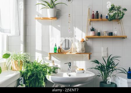 Bagno moderno bianco in stile ecologico. Ombre dalla finestra sul muro di tegole in giorno di sole. Zero rifiuti, prodotti ecologici, sostenibilità. Giungla urbana. Design bifilico dell'interno Foto Stock