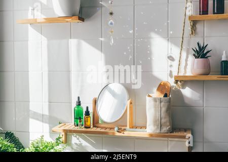 Il cristallo del catcher del sole che fa molti fasci di somma e macchie di luce sulla parete bianca della mattonella alla giornata di sole. Bagno moderno e ecologico dal design minimalista bifilico Foto Stock