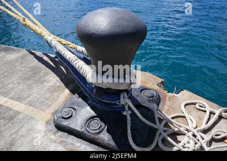 Grande nave da mare ormeggio su banchina di cemento con funi di ancoraggio attaccate Foto Stock