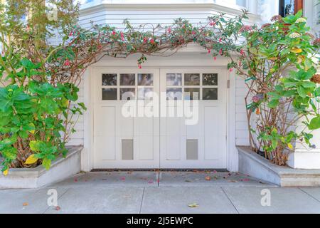 Esterno garage bianco con doppia porta a cerniera laterale a San Francisco, California Foto Stock