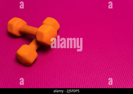 Spazio fitness arancio mat dumbbell palestra sfondo viola bianco, da wellness fit per legno da banner attivo, ragazza isolato. Casa di salute, Foto Stock